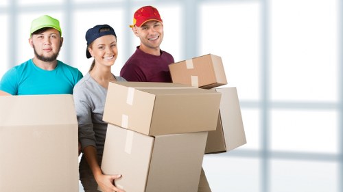 Staff carrying and securing boxed items during a move